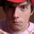 Static 50x50 pixel icon showing a close-up of a person's face with red headwear, brown hair, and light skin tone against a dark background.