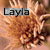 Pixelated image with text 'Layla' overlaid on a blurred background of warm brown and orange tones.