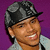 Pixelated portrait of a person wearing dark cap and light shirt against purple background, smiling with visible teeth.