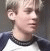 Pixelated image of a person with light hair wearing a white and dark blue raglan shirt, next to black background with pixelated text.
