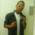 Pixelated image of a person in dark clothing with arms crossed, standing against a light background.