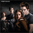 Four people in dark clothing pose closely together against a black background with subtle gray gradients.