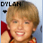 A young person with light brown hair and a red garment smiles broadly, with 'DYLAN' text above and a small black star symbol in the top-left corner.