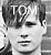 Black-and-white animated contact sheet of a person's face with text "TOM" above the head across three frames showing subtle facial expression changes and hair movement.