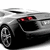 Pixelated silver car with red taillights, black wheels, and visible tire tread, angled to show front-left side against white background.