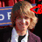 four pixelated images showing a person with light brown hair in various group poses, some with red triangular overlays