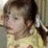 A child in a yellow shirt with brown hair styled in pigtails appears to move slightly