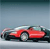 A red sports car with a white roof is positioned on a light gray surface against a gradient background transitioning from dark blue to light gray.