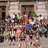 A pixelated group photo of people in front of a building with a red displaying text on the right side