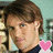 Pixelated image of a person with brown hair and light skin, wearing dark clothing, positioned against a blurred background with pink heart symbols.