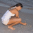 Pixelated static image of a person in a crouched pose wearing white shorts and dark hair against a gray background.