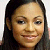 Pixelated close-up of a person with long dark hair, light brown skin, and a neutral expression against a light background.