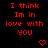 Red pixelated text on black background reads "I think Im in love with you" with two red heart symbols below.
