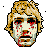 Pixelated face with blonde hair and red splatters on a gray background, displayed in a of