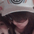 A person with long dark hair wears a light-colored hat featuring circular patterns, shown in multiple overlapping views.