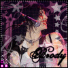 A woman with dark hair and tattoos sings into a microphone, wearing a white top with black straps, against a purple starry background with "Brody" text.