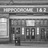 Static grayscale image of a pixelated building facade with rectangular windows and horizontal lines, resembling a theater entrance or storefront.