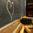 A pixelated image shows a heart-shaped wire on a dark wall above a wooden desk with a black object, next to text reading 'UGH.....' and 'SCHOOL!' in brown block letters.