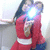 Two people in red outfits embrace, one holding a bright light source that obscures their faces against a plain background.