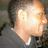 A pixelated static image shows a person's face with light skin and short dark hair, partially obscured by bright overexposure on the right side.