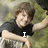 A person in a black shirt leans on a stone structure with grassy background, text changes from 'I' to 'LOVE' then 'HIM!!!!'