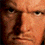 Pixelated close-up of a human face with light brown skin tone, dark eyes, and visible nose and mouth features.