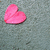 A single pink heart-shaped icon with a dark outline sits on a pixelated gray background.