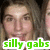 A pixelated close-up of a person with light skin and brown hair, overlaid with green text reading 'silly gabs' on a white background.