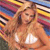 A pixelated image of a person with long hair wearing a white top, set against a colorful striped background.