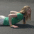 A woman in a green top and white bottoms performs push-ups on a gray surface, her head turning from left to right across frames.