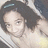 Pixelated static image of a person with dark hair and a light-colored top, cropped to show upper body and head.