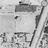 Grayscale pixelated image of a stylized building with a sloped roof and vertical lines, possibly a theater, with indistinct text below.