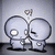 Two stylized cartoon figures with large circular heads and simple limbs stand side-by-side against a gradient background.