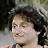 A pixelated image of a person with dark curly hair on the left side and black text reading "Mork calling Orson..." on the right side, displayed as part of an animated contact sheet.