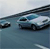 A static pixelated image shows a dark-colored vehicle on a road with blurred motion effects, set against a light sky background.