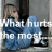 Pixelated image of a person in blue clothing with overlaid white text reading "What hurt me most" against a gray background.