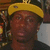 A person wearing a yellow cap with a black brim and dark clothing, shown in a of four with varying background elements