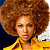 Pixelated portrait of a person with voluminous brown afro hair wearing a yellow collared shirt against dark and light background sections.