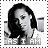 Pixelated grayscale image of a person with long dark hair holding a microphone, with text below reading 'AS I AM'.