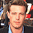 A pixelated image of a person with light brown hair and a blue shirt, next to a bright pink background with pixelated text.