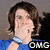 Pixelated image of a person with brown hair wearing blue clothing, holding hand near face, with 'OMG' text in bottom right corner.