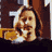 Pixelated static image of a person with light brown hair and mustache holding a yellow object against dark background.
