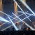 Pixelated abstract composition with diagonal light streaks and scattered color blocks in blue, white, and brown tones.