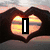 A four- shows hands forming a heart shape over a sunset, sand with 'LOVE' written in it, a person doing a handstand, and a blank