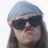 A person with long brown hair wears a light blue headscarf and dark sunglasses, showing slight variations in facial expression across frames.