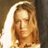 Static pixelated image of a person with light brown hair and closed eyes, wearing a white head covering against a dark background.