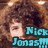 A pixelated image of a person with curly brown hair, featuring blue text reading 'Nick Jonas!!!' overlaid on the upper portion.