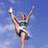 A static image of a cheerleader mid-kick against a blue background with orange pixelated text reading "IT'S NOT AS EASY AS IT LOOKS" arranged around the edges.
