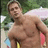 A pixelated static image shows a shirtless man with short brown hair standing outdoors, holding a yellow object in his right hand and a pink item in his left.