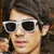 A person with dark hair and white-framed sunglasses appears in a of four , each showing slight variations in facial expression and background